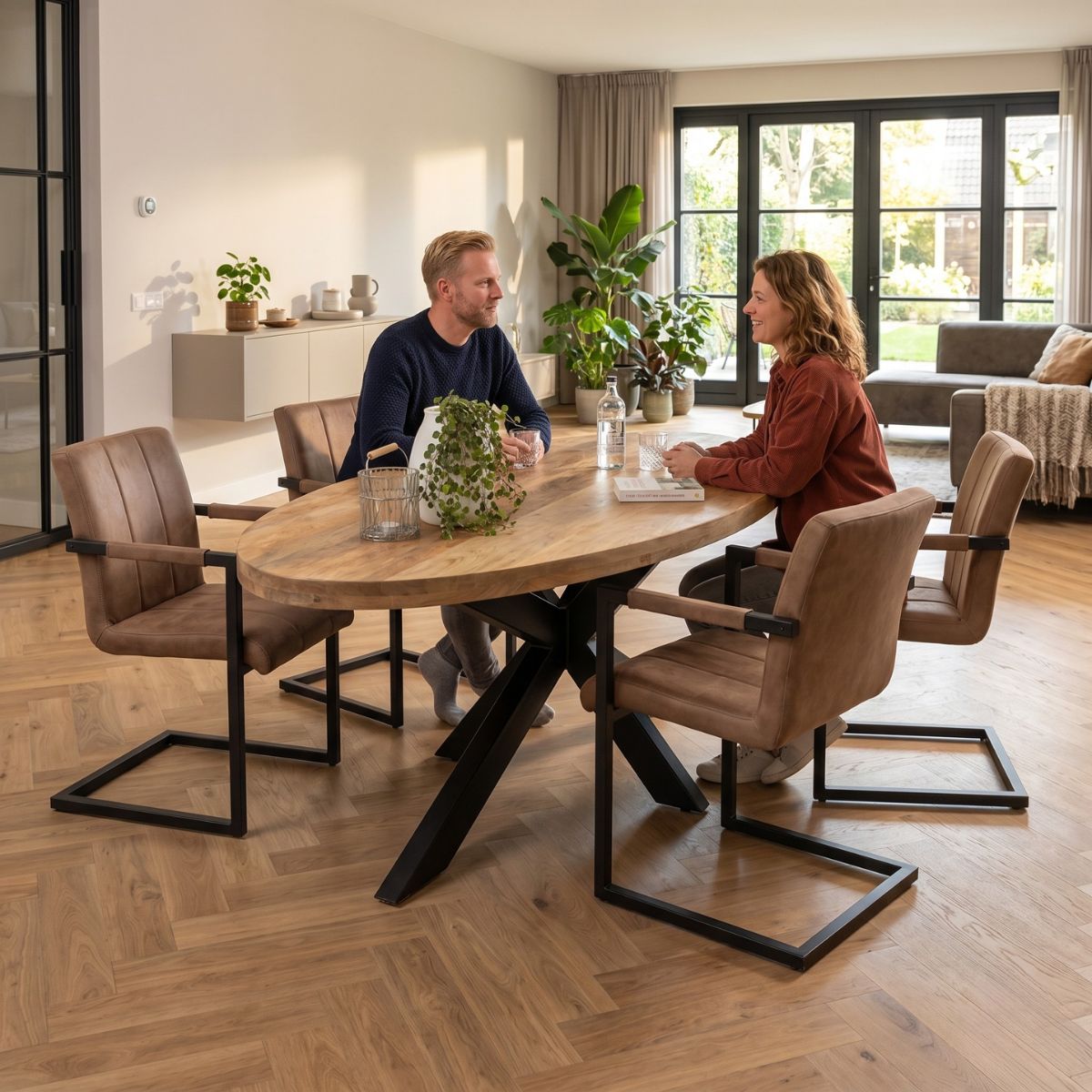 Lichtbruine ovale eettafel van mangohout met zwart onderstel