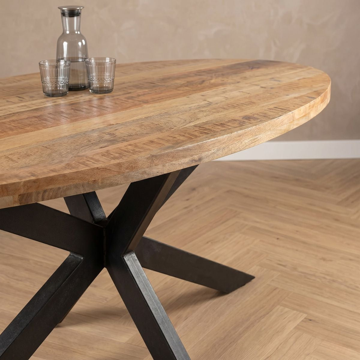 Lichtbruine ovale eettafel van mangohout met zwart onderstel
