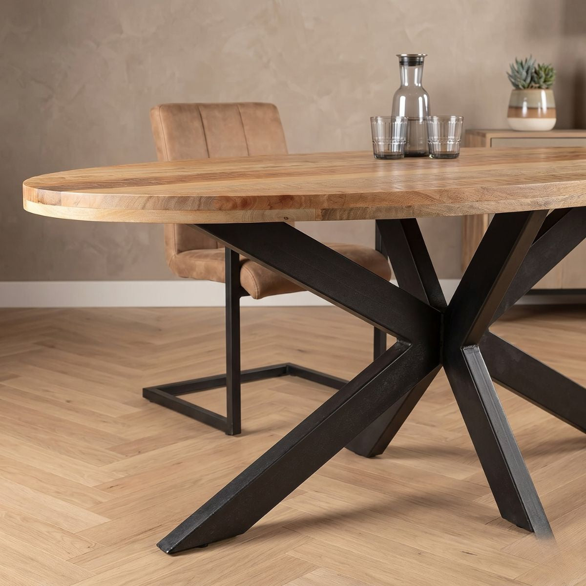 Lichtbruine ovale eettafel van mangohout met zwart onderstel